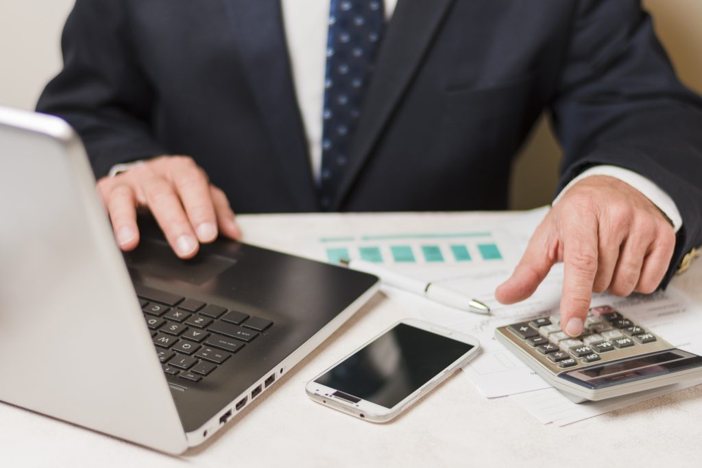 Businessman Using Calculator 1024x683