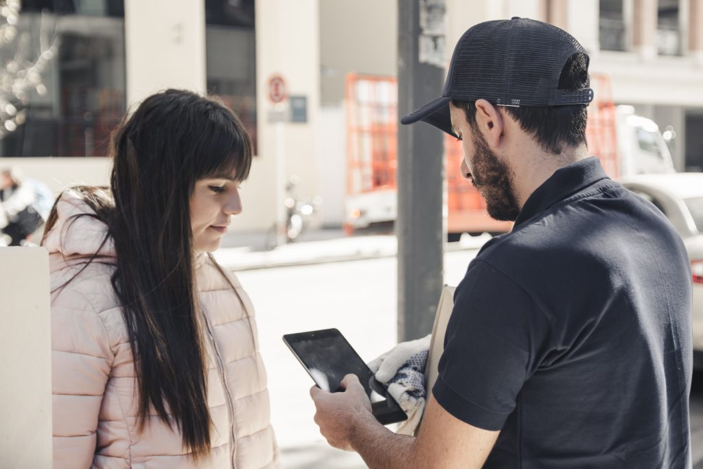 Delivery Man Using Digital Tablet Near Female Customer 1024x683